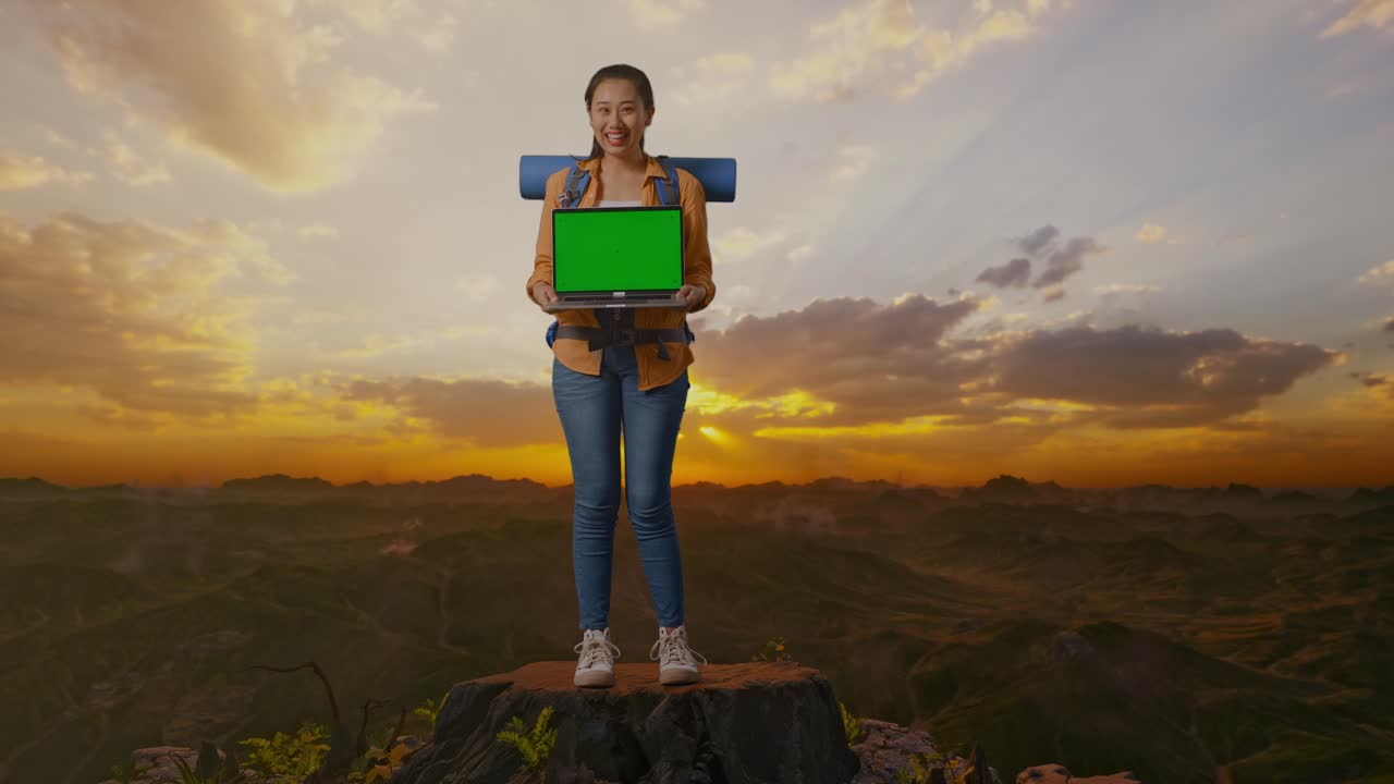 mujer con computadora portátil en la cima de la montaña al atardecer