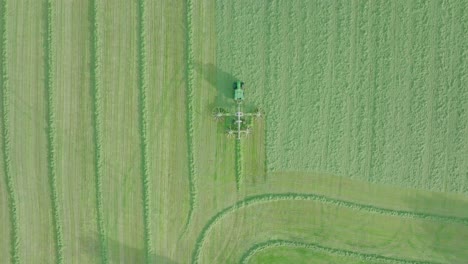 aerial tracking shot of a farmer cutting silage on a warm summer day, scotland