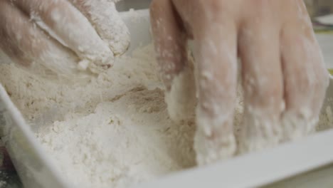 mixing chicken meat in cooking flour inside small ceramic plate