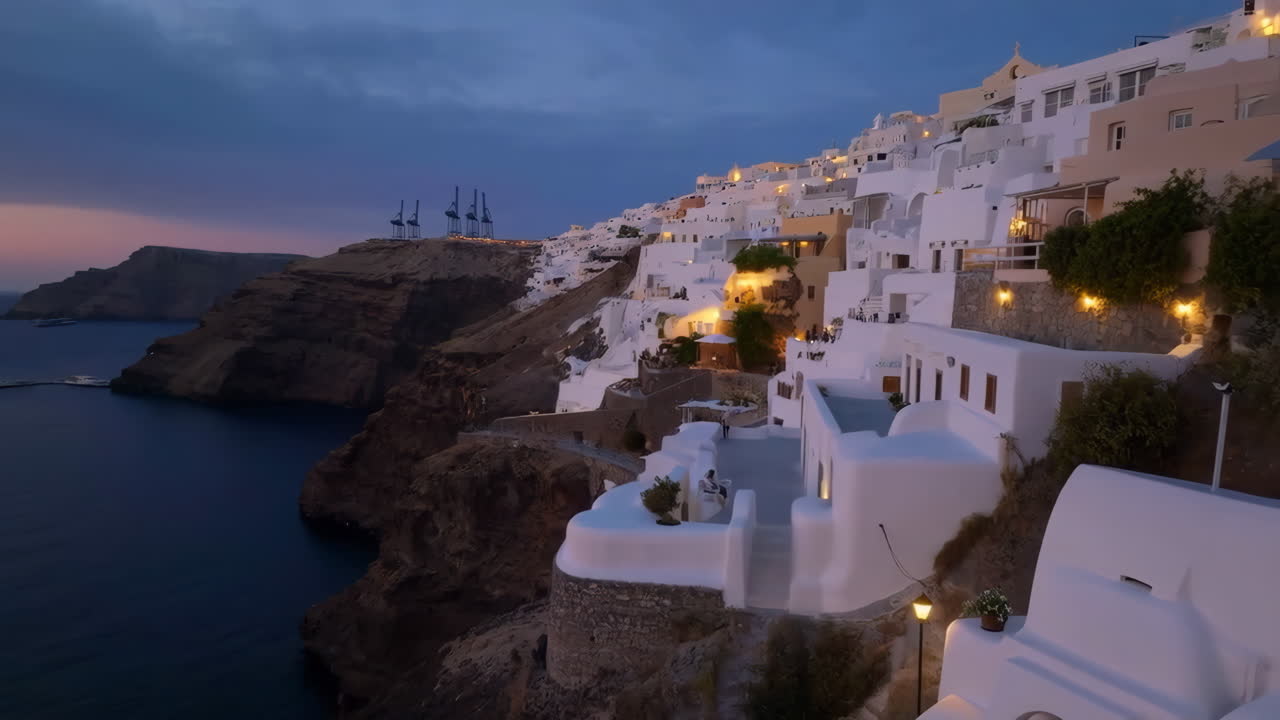 Santorini-like Coastal Village at Dusk with Illuminated White Buildings