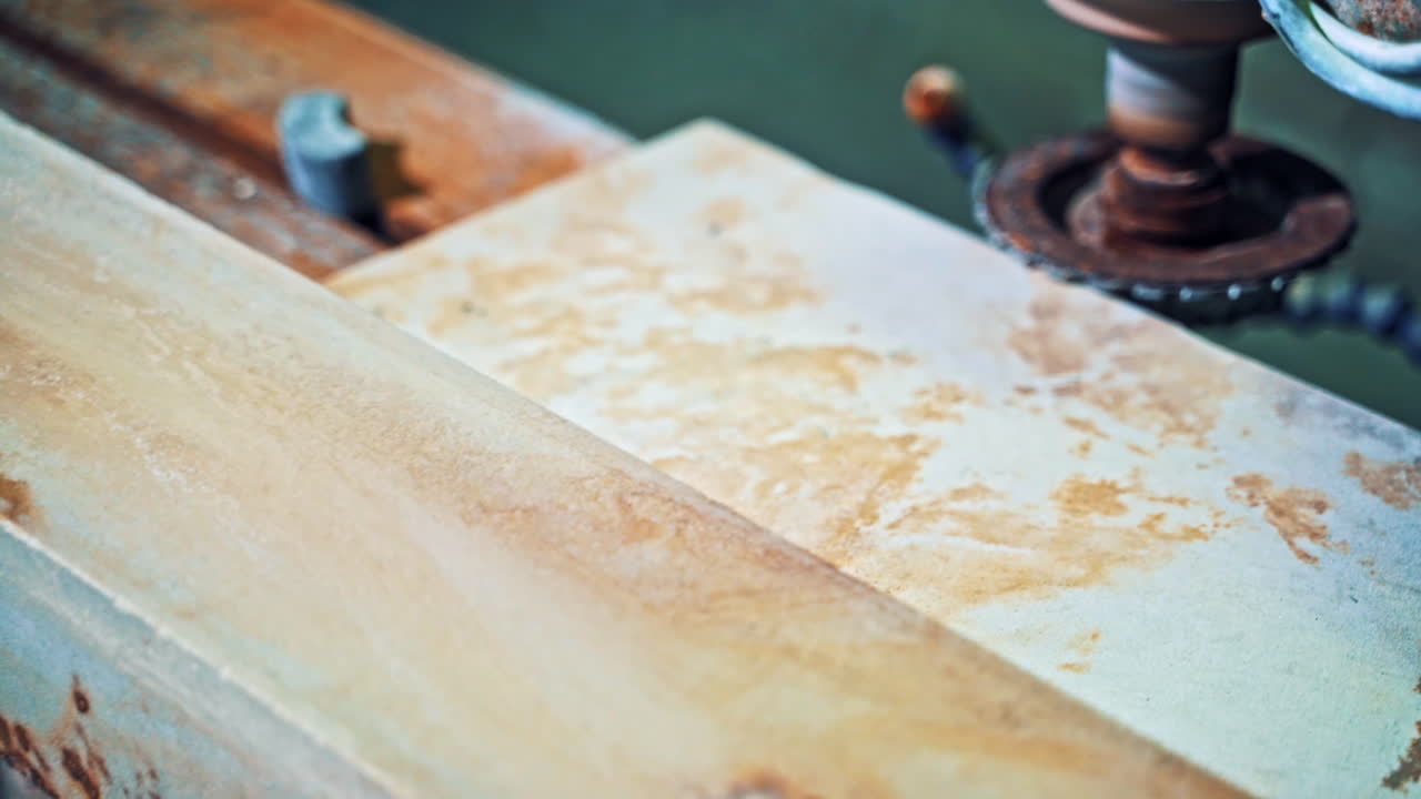Worker processes granite stone. Grinder worker cuts stone block with electric saw