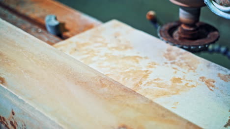 Worker processes granite stone. Grinder worker cuts stone block with electric saw