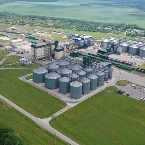 modern factory among fields. grain elevators for keeping agricultural products. grain storage tank in the countryside. aerial view.