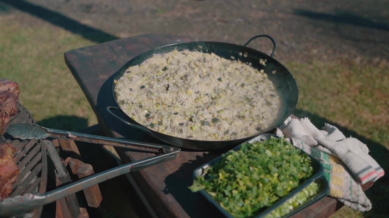 Ulkokeittiön lähikuva, jossa valmistetaan riisiä ja vihanneksia perinteiseen argentiinalaiseen grillaukseen.