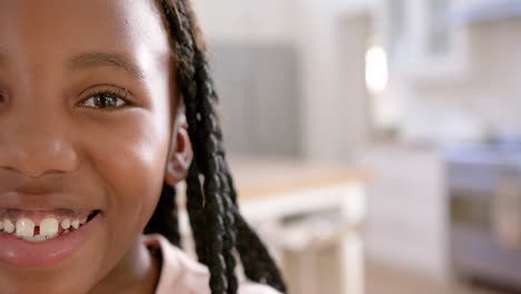 portrait of happy african american girl with long hair at home, slow motion, copy space