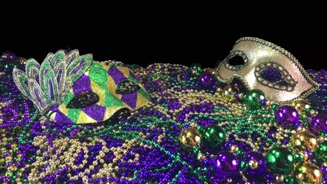 sparkling colorful carnival masks on pile of mardi gras beads