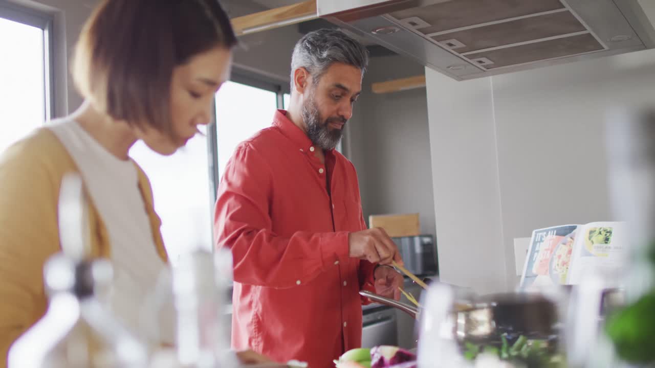 pareja feliz cocinando juntos, mezclando ingredientes en la olla en la cocina
