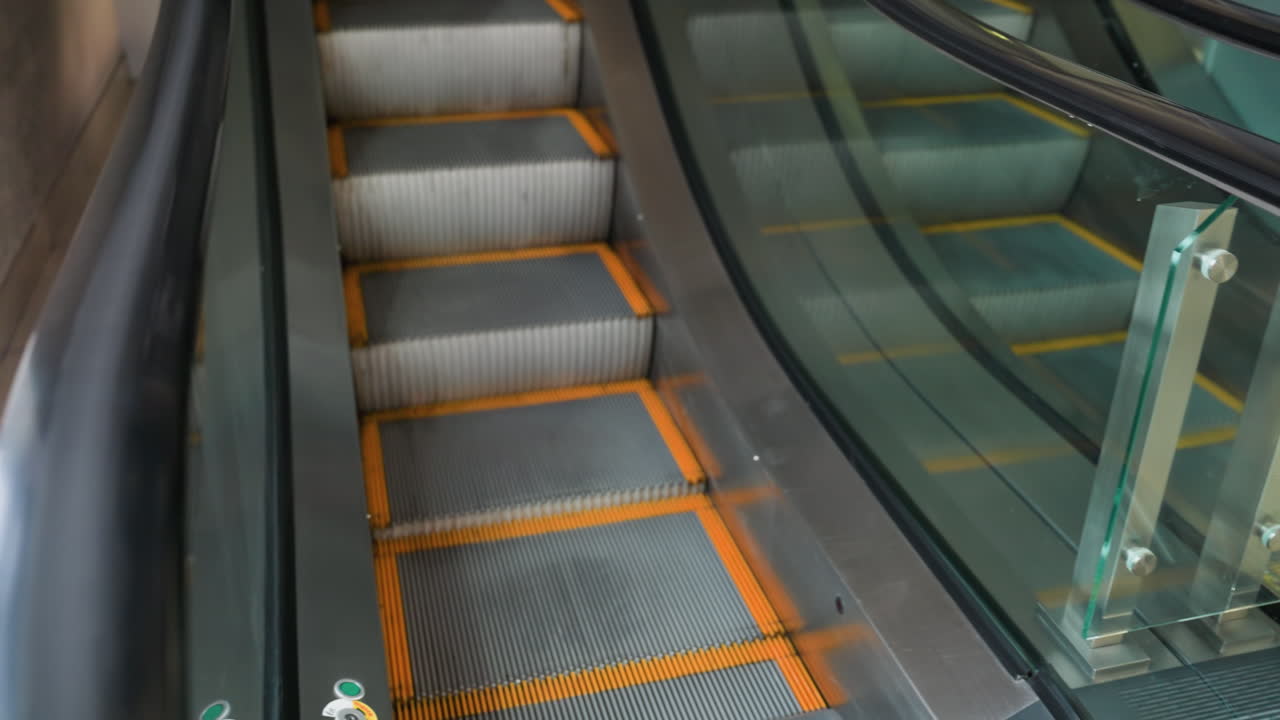 두 개의 에스컬레이터의 근접한 시야를 보여주는 1인칭 관점, 하나는 올라가고 다른 하나는 내려갑니다.