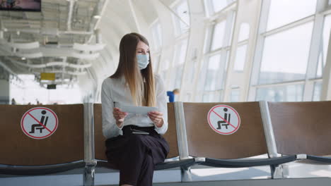 woman waiting at airport with mask on