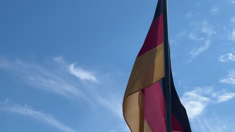a german flag blowing in a light breeze outside a golf club in cape town.