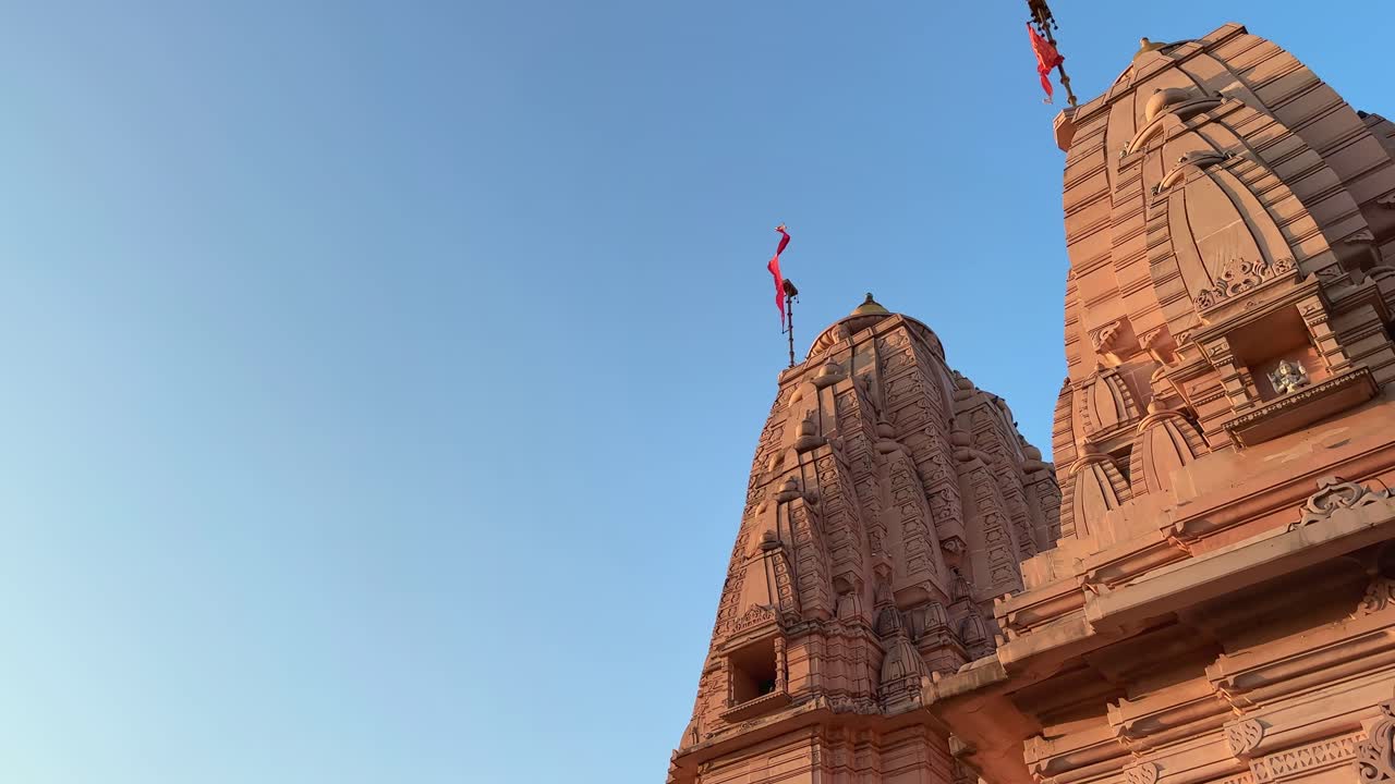 A hindu temple with red hindu flag wavering at the top