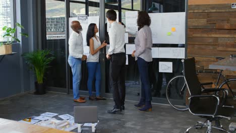 executive discussing over document on glass wall 4k