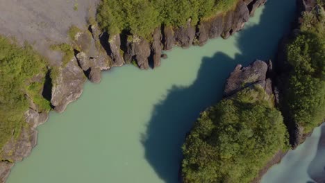 Aerial-drone-moving-shot-of-silent-water-flowing-in-between-the-rocks