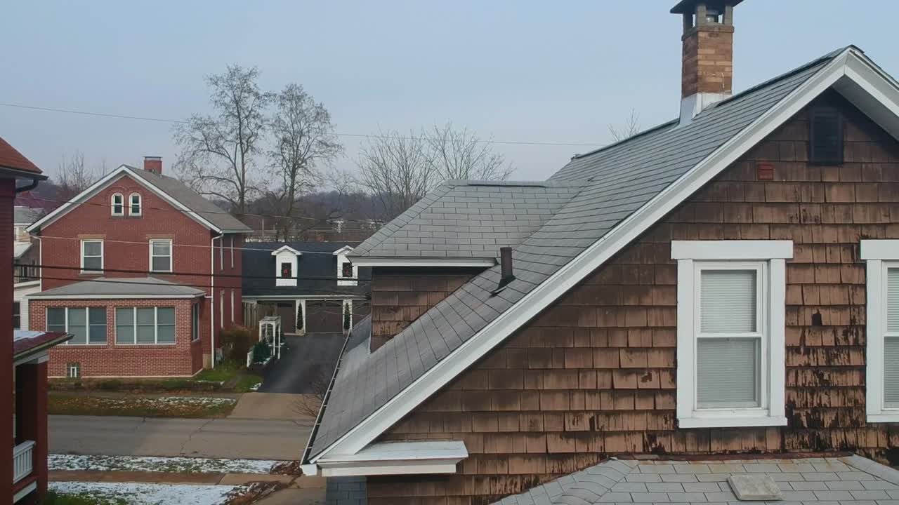 Drone shot starting at ground level and revealing a town or suburb.