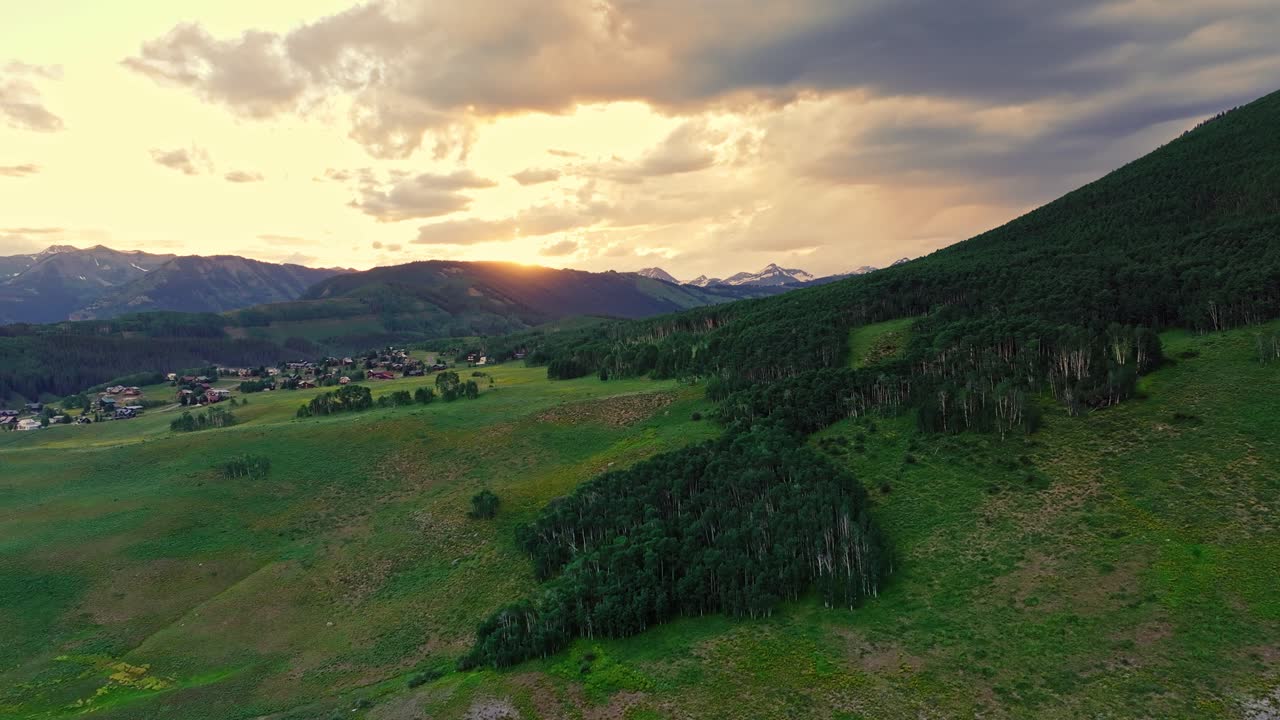Aerial at sunset over a lush green valley near Crested Butte mountain, Colorado, USA