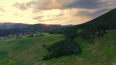 Antena-Al-Atardecer-Sobre-Un-Exuberante-Valle-Verde-Cerca-De-La-Montaña-Crested-Butte,-Colorado,-Ee.uu.