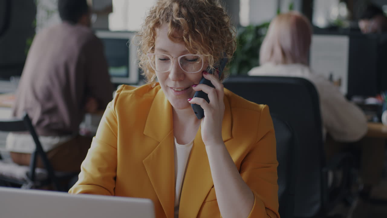 Kvinne i telefonsamtale på moderne kontor