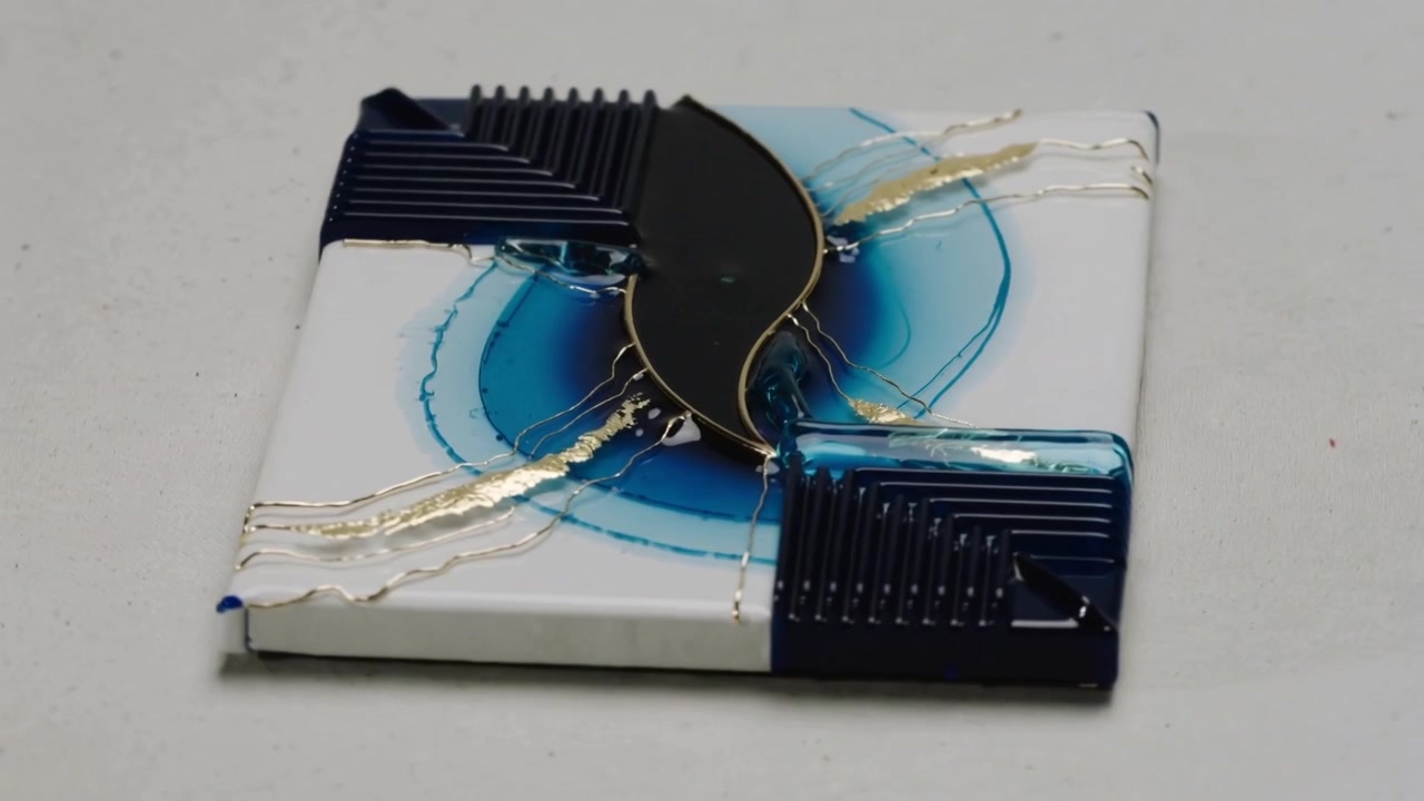Orbiting camera revealing square tile on studio table, resin, gold-veins, blue-rings, navy-corners