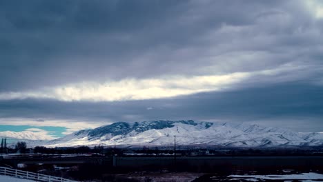 Storm-blowing-in-over-the-snowy,-winter-mountains---cloudscape-time-lapse