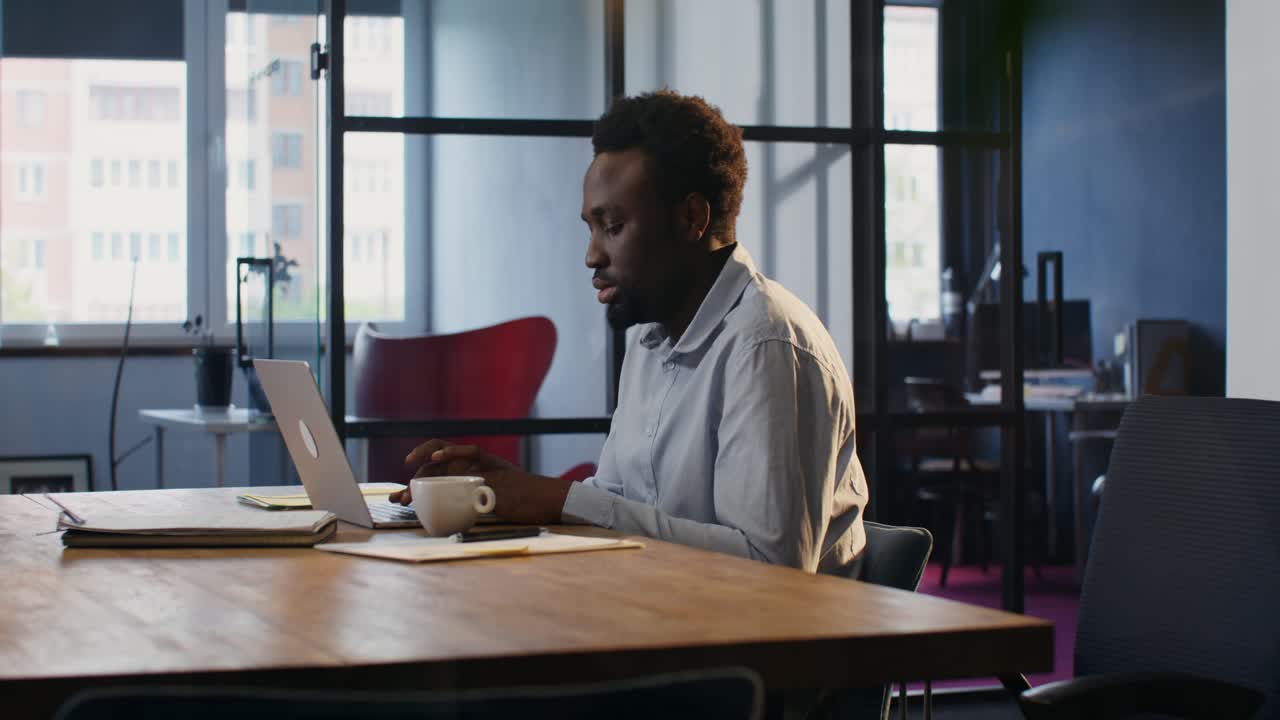 Man Working on Laptop in Modern Office