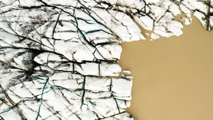 Aerial down shot of cracks on the glacier lake located in Fjallsárlón, Iceland