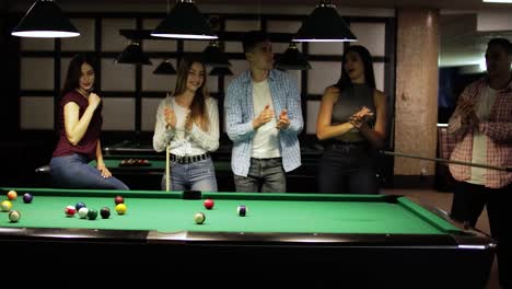 friends joyfully play billiards.