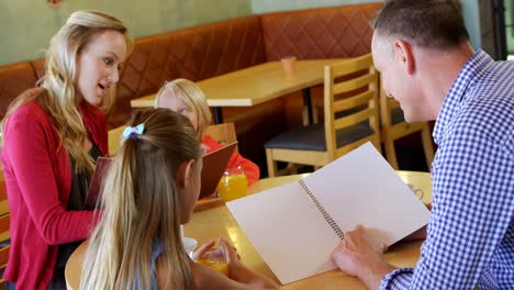 Family-looking-at-the-menu-in-restaurant-4k