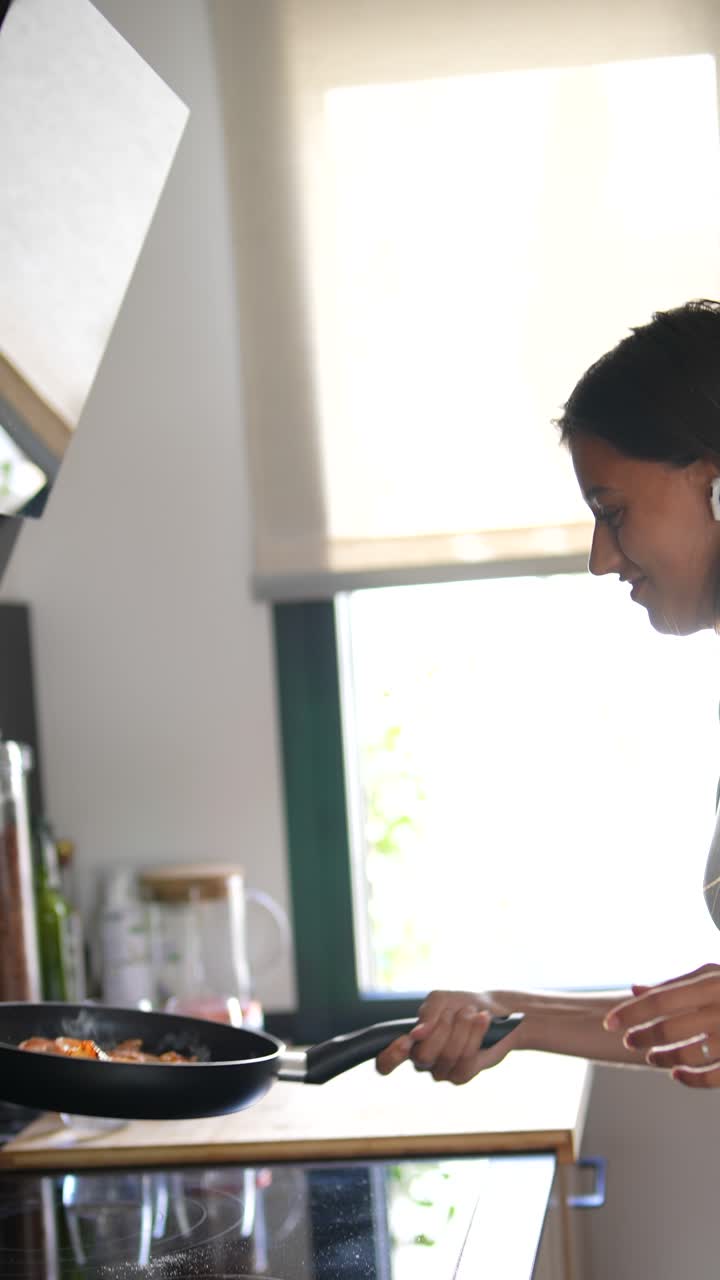 mujer cocinando camarones en la cocina