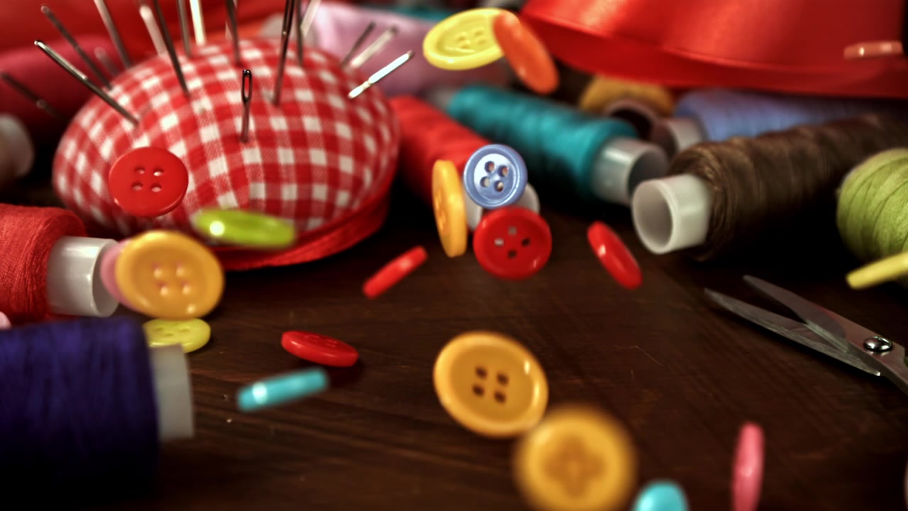 Colorful Sewing Buttons Falling and Bouncing on a Wooden Table
