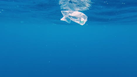 Schwimmender-Plastikmüll-Auf-Der-Wasseroberfläche,-Zeitlupe-Unter-Wasser