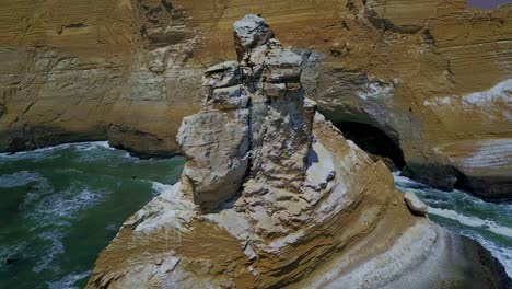 aerial orbital view of la catedral rock along the steep cliffs with pacific ocean waves in peru, south america