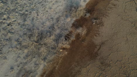 fly over an old abandoned fisher boat on a dry dead sea ground, aerial shot