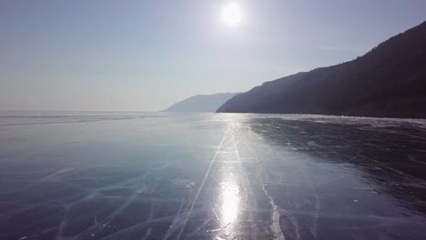 Drone-Volando-Hacia-Adelante-Y-Bajo-Sobre-Agua-Congelada-Cinematográfica-En-Rusia,-Famoso-Lago-Baikal