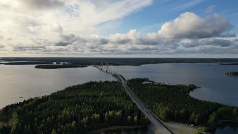 finland autumn landscape with forest and bridge over lake, aerial view