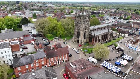 People-queuing-at-market-stall-Tamworth-Staffordshire,-UK-drone,aerial-St-Editha's-Parish-Church