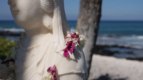 Lei-Hangs-on-Statue-on-Beach-in-Hawaii