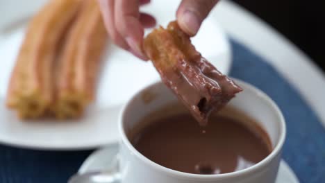 Eine-Zeitlupenaufnahme,-In-Der-Spanische-Churros-In-Heiße-Schokoladensoße-Getunkt-Werden