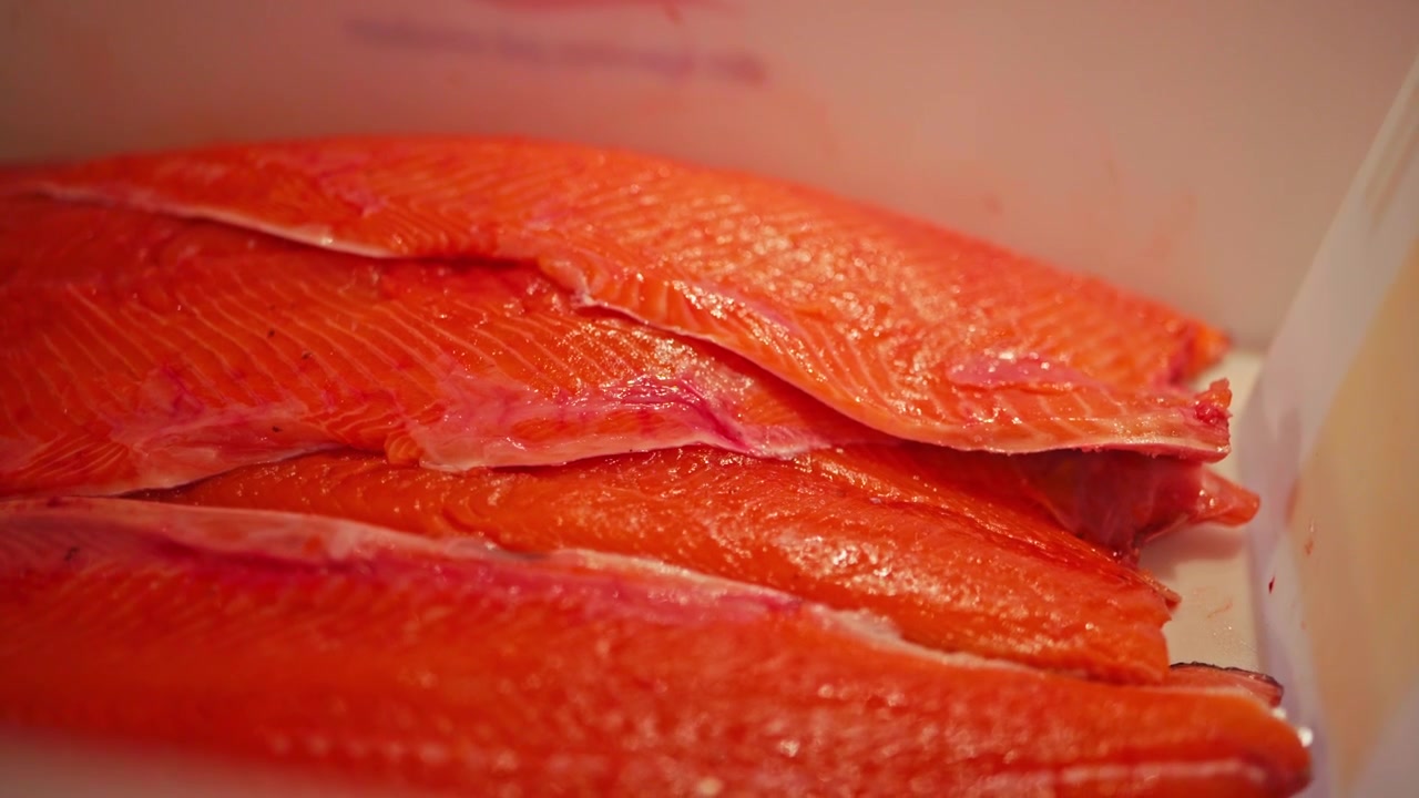 Filetti di salmone vivaci, ordinatamente impilati e pronti per essere cucinati - Primo piano