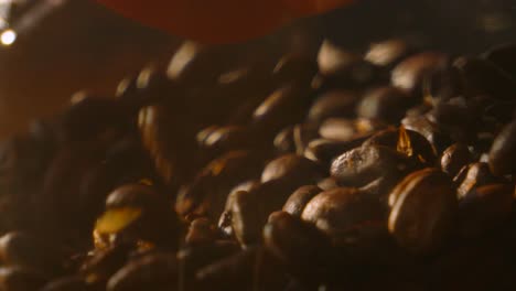 barista hand grabbing brown roasted coffee beans in slow motion ready to grind and make into delicious hot beverage. close up fresh morning caffeine drink using natural ingredients ready to blend.