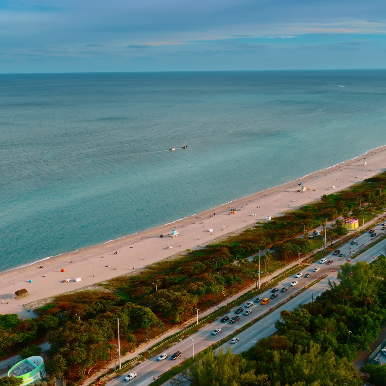 Busy highway with multiple cars along the sandy beach of the Atlantic Ocean. Top view of the coast in Miami, Florida, USA.