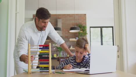 padre ayudando a su hijo en la tarea en casa 4k