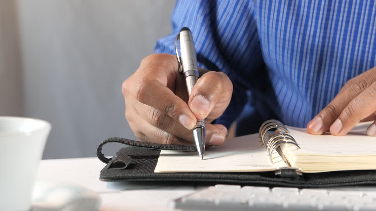 Person Writing in a Notebook