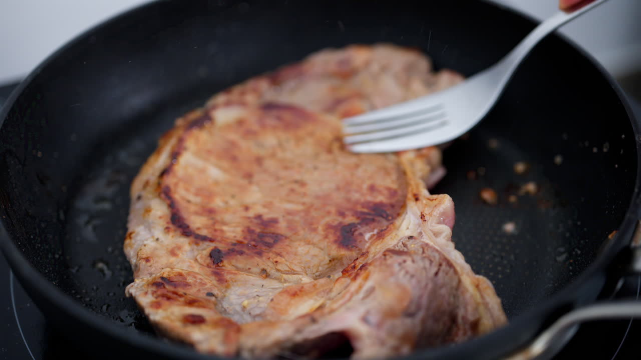 Woman cooking a rump steak on a pan