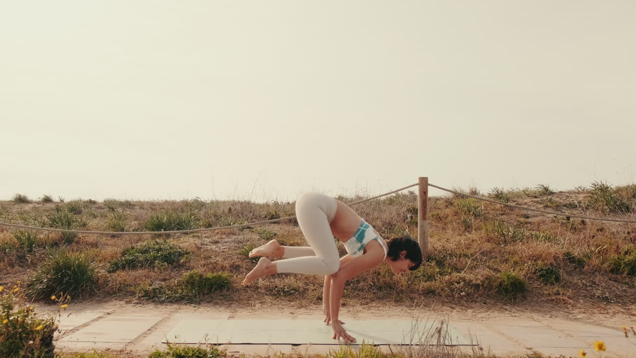 Junge Frau praktiziert Yoga-Pose im Freien auf der Matte