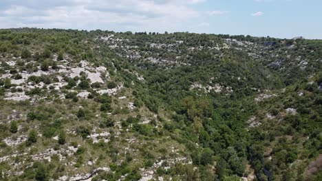 Aeial-tilt-up-shot-showing-overgrown-mountain-landscape-in-Sicily-in-Italy