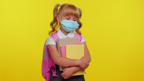 Unhealthy-teen-schoolgirl-kid-wearing-protective-medical-mask,-standing-with-books-looking-tired