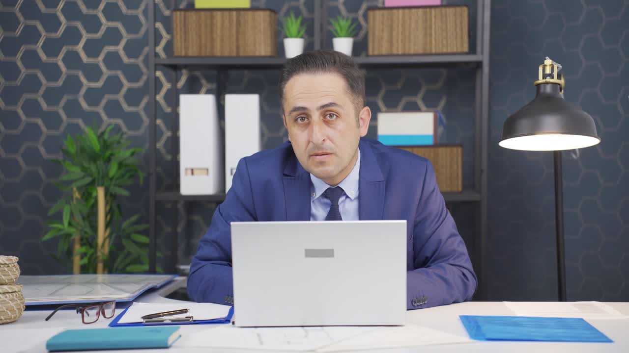 사업가는 놀라움과 혼란으로 카메라를 쳐다보고 있습니다.