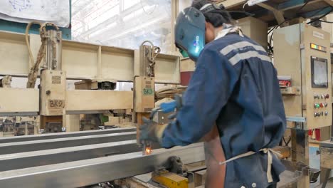 factory worker welding metal beams
