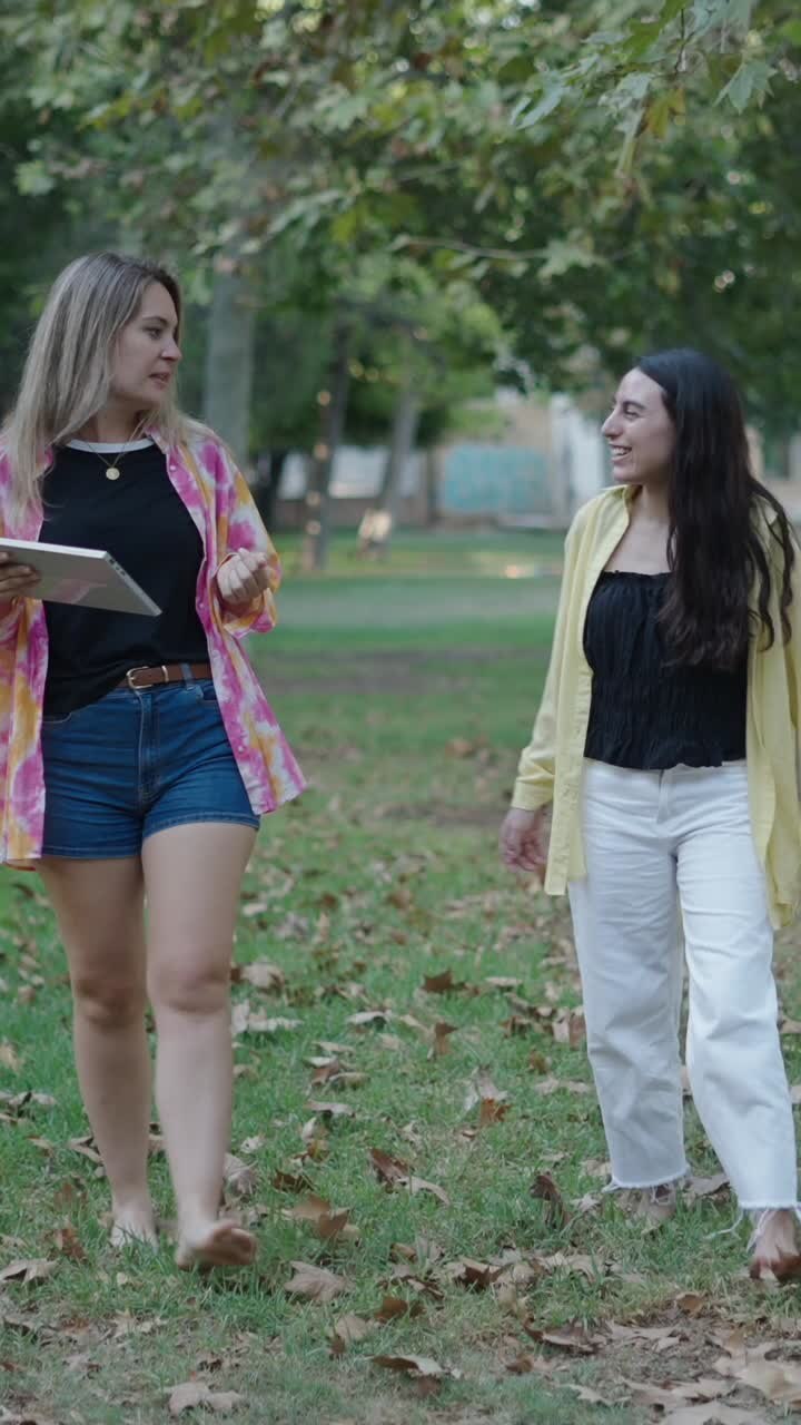 Two women walking and talking in a park
