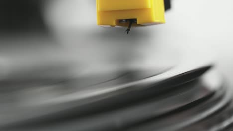 vinyl player turntable. a fragment of a rotating vinyl record, a stylus with a needle close-up. stopping a needle and a vinyl plate close-up. macro. view from above